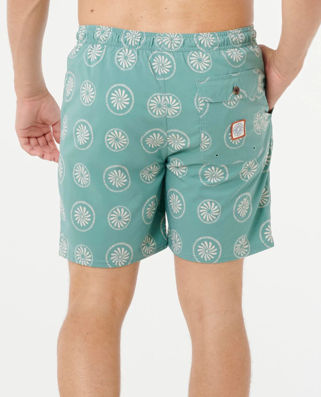 Teal swim shorts with white pattern worn by a person on a white background