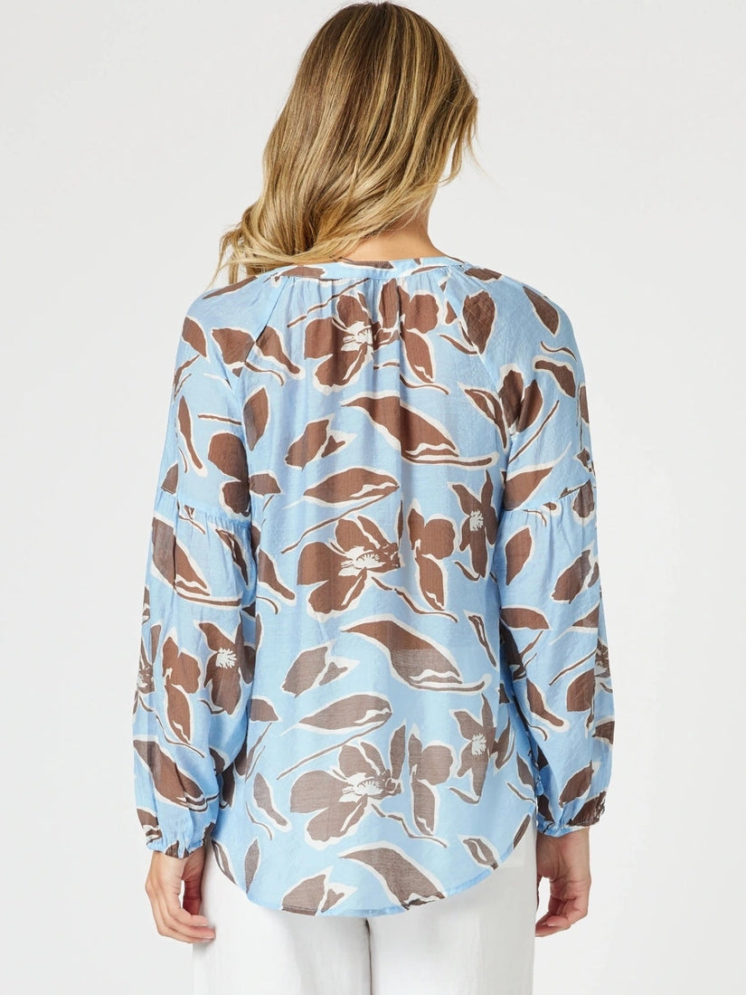 Woman wearing a floral blouse with a light blue background