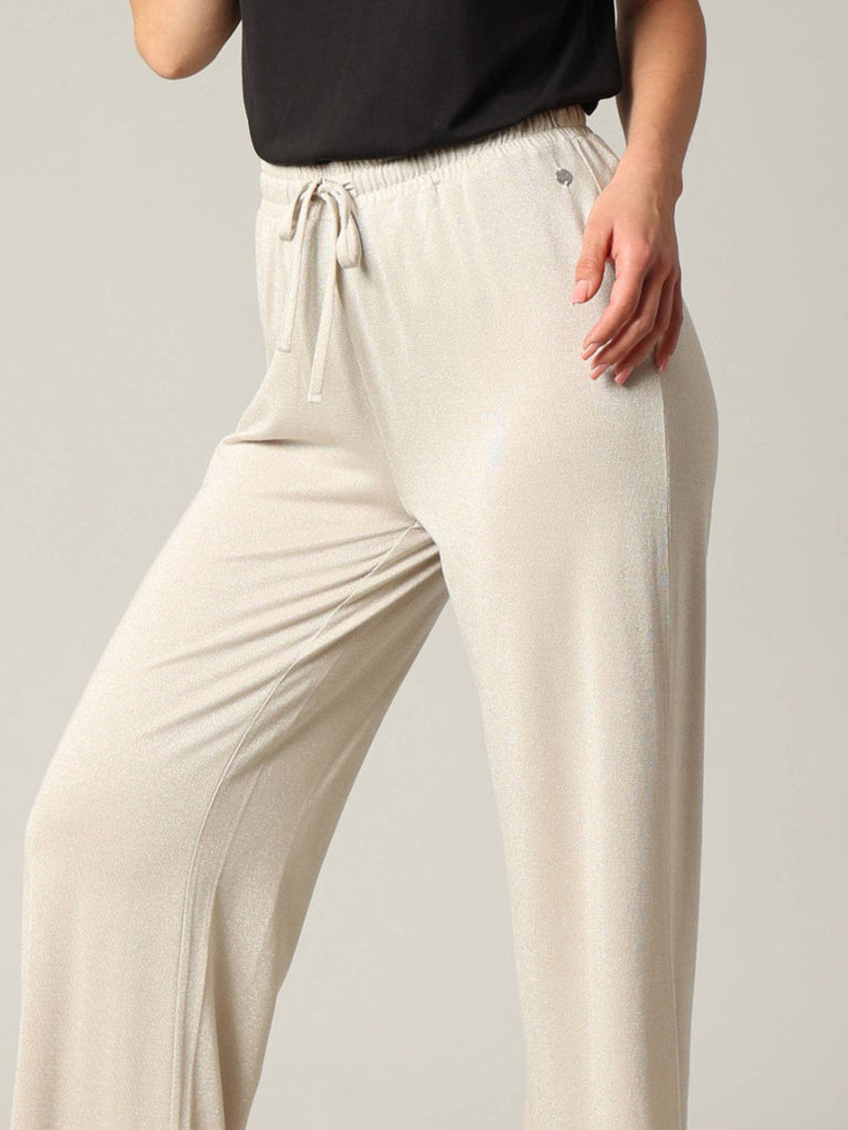 Beige lounge pants worn by a person on a plain background