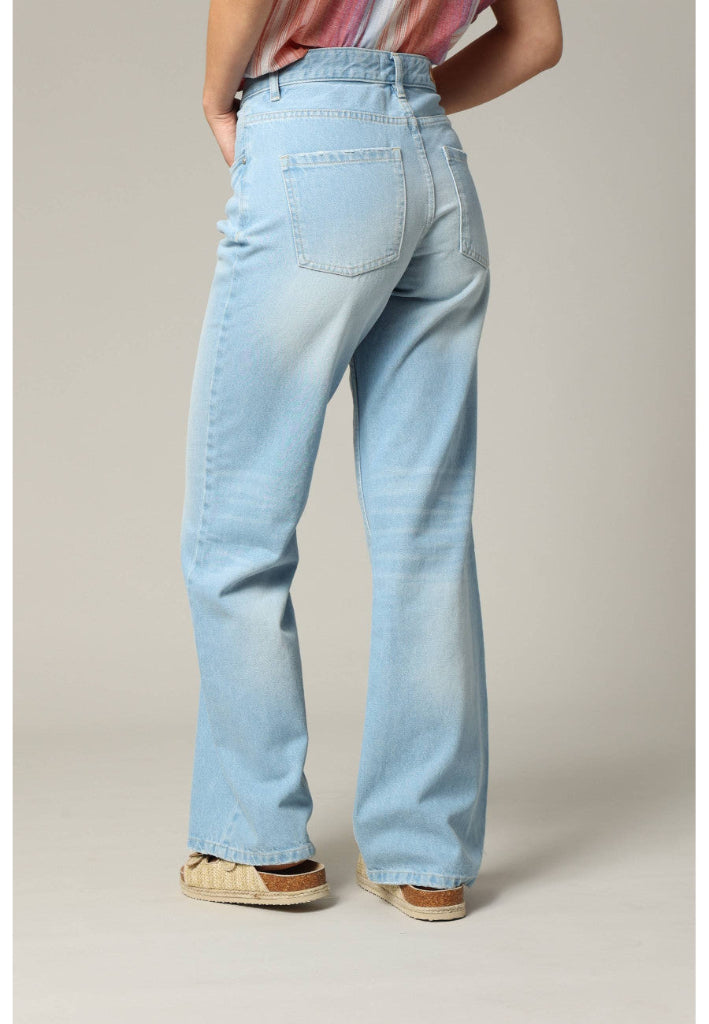 Light blue jeans worn by a person on a plain background