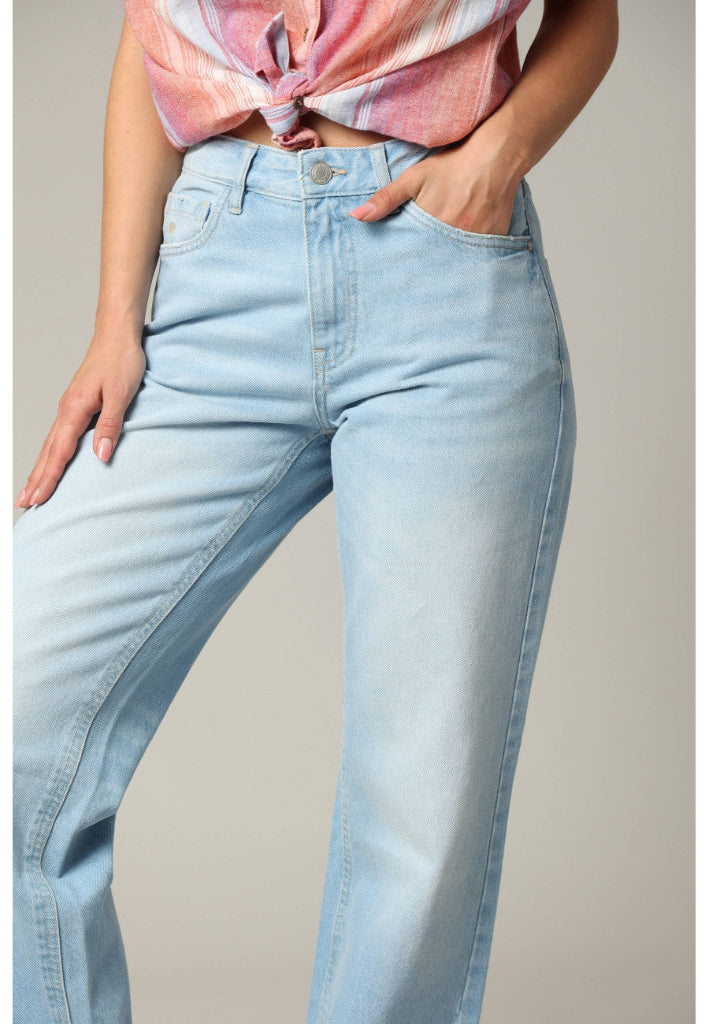 Light blue jeans worn by a person on a neutral background