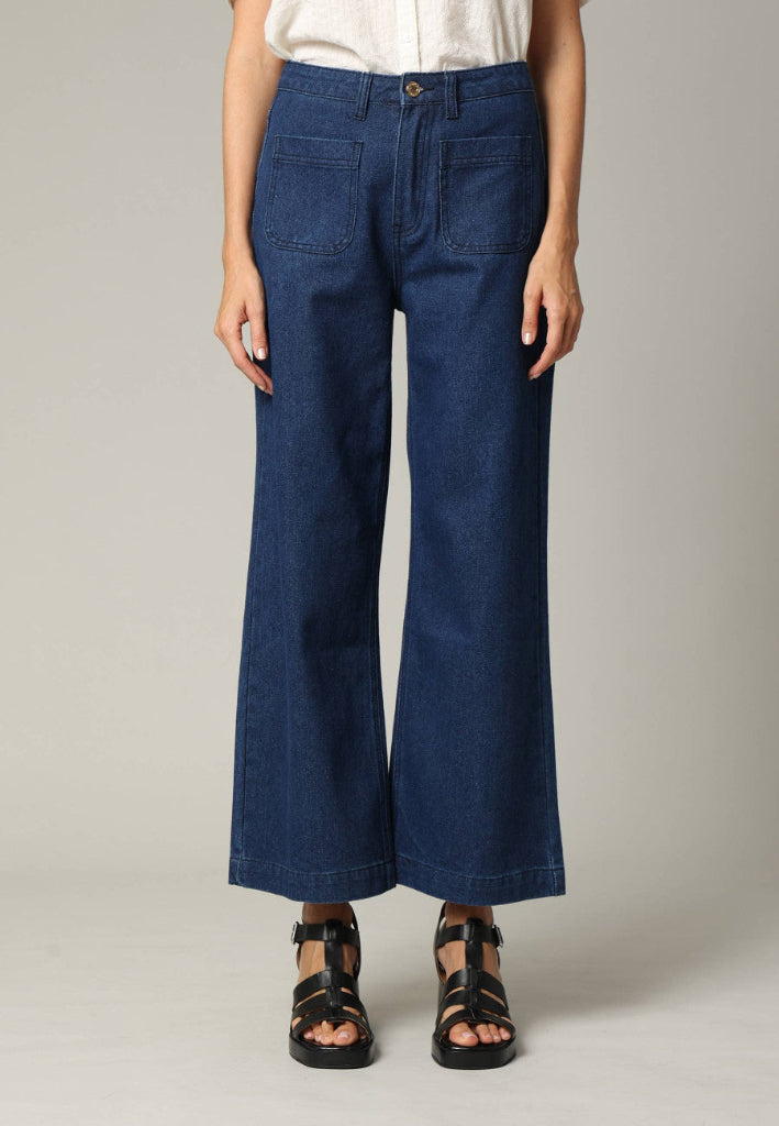Person wearing blue wide-leg jeans on a plain background