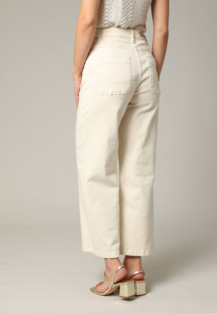 Person wearing beige high-waisted pants on a plain background