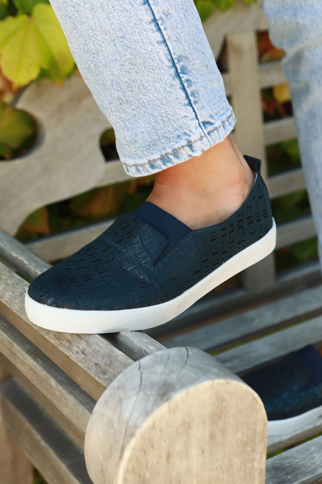 side view on model low slip on navy shoe with snakeskin print