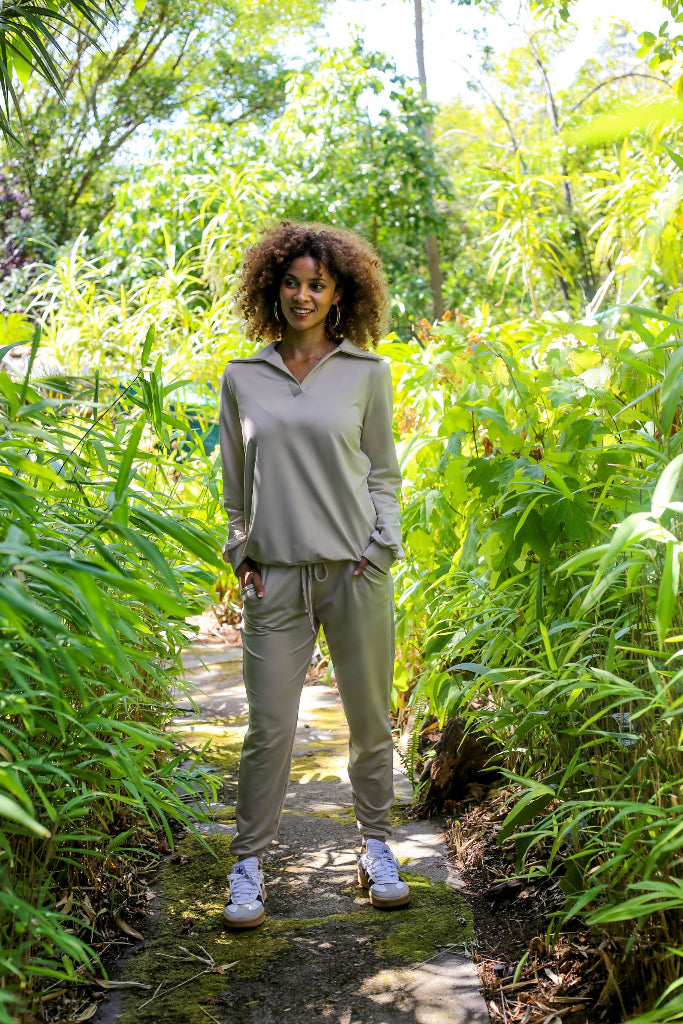 Woman standing on a path surrounded by greenery in a forest setting