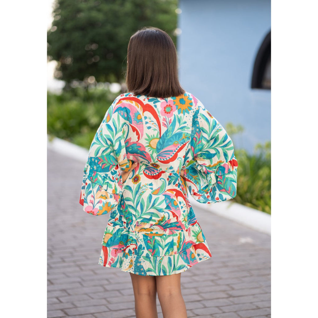 Woman wearing a colorful floral dress with a blurred outdoor background