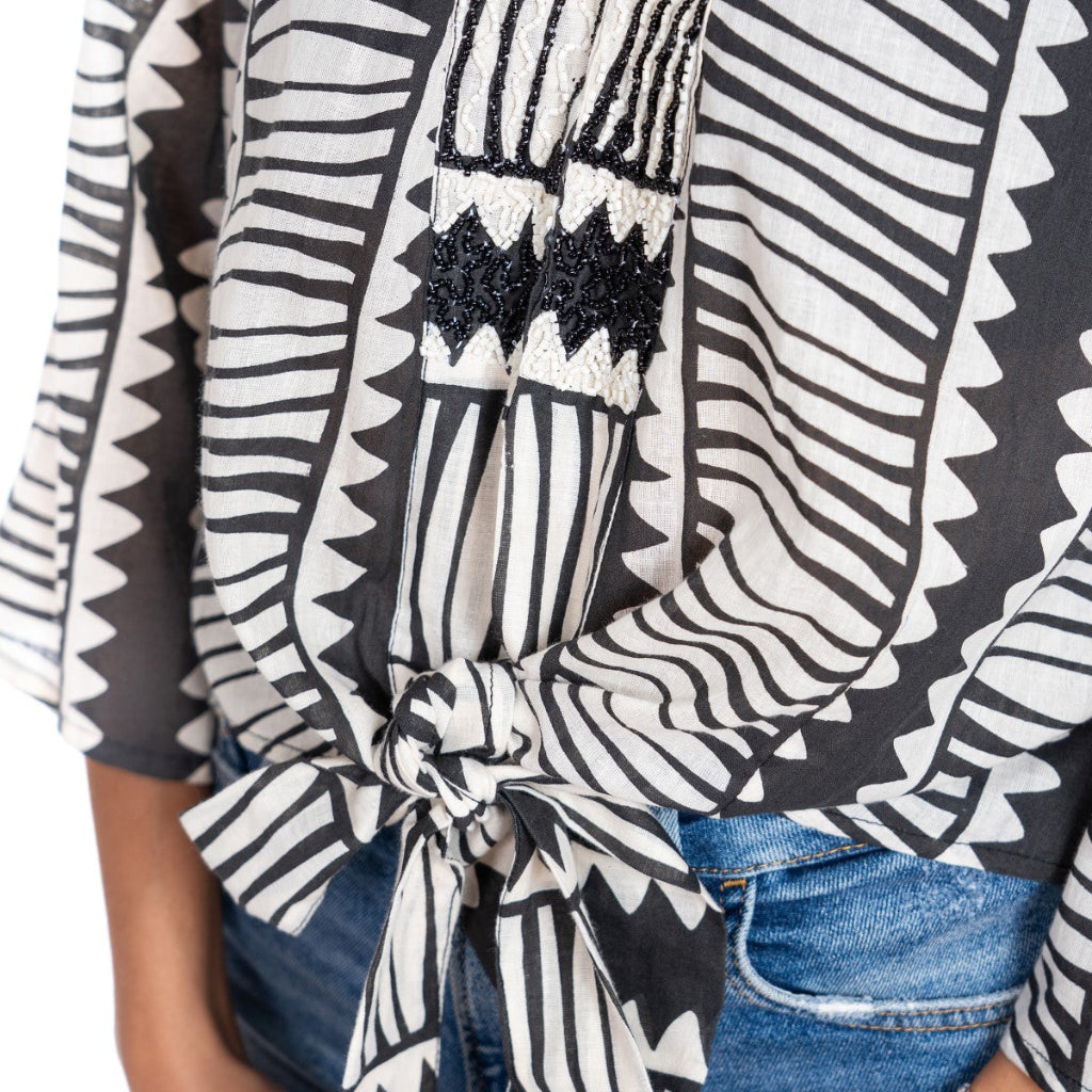 Black and white patterned top with a knot detail on a white background