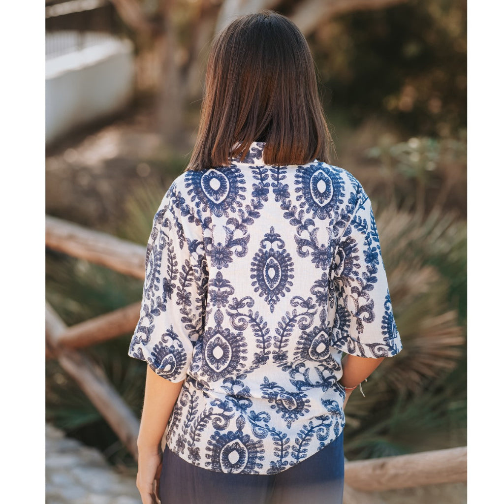 Woman wearing a blue and white patterned blouse outdoors