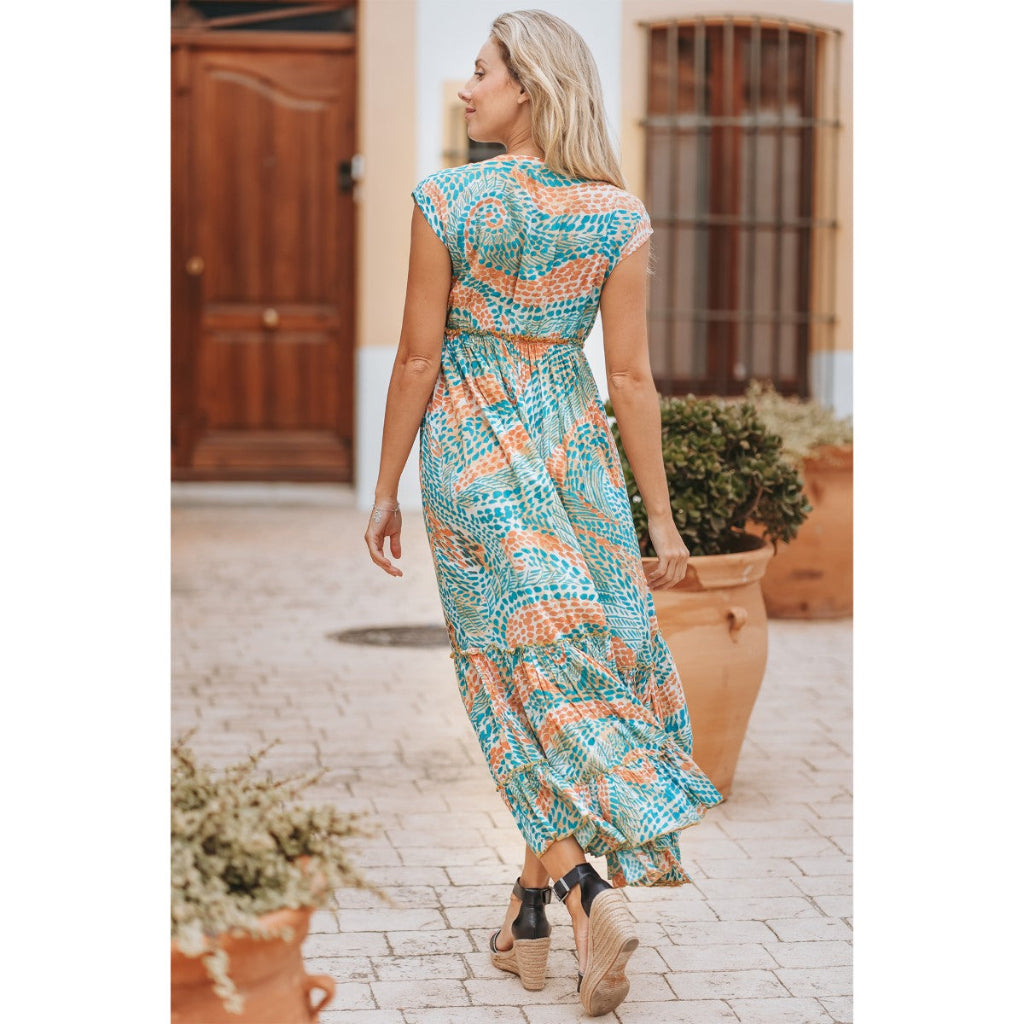 Woman wearing a colorful patterned dress walking outdoors.