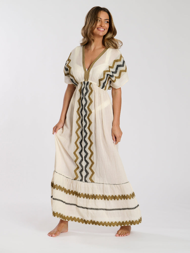 Woman wearing a long, patterned dress on a white background