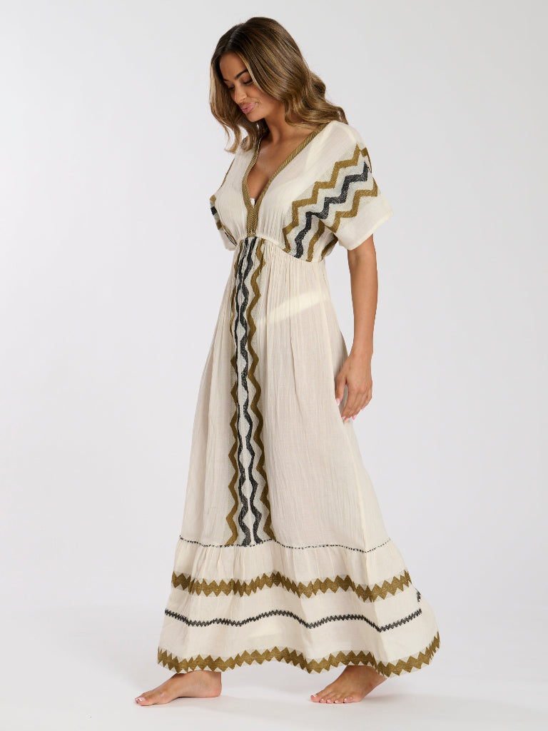 Woman wearing a long, patterned dress on a white background