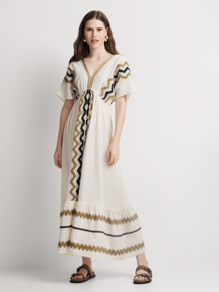 Woman wearing a long, patterned dress on a white background