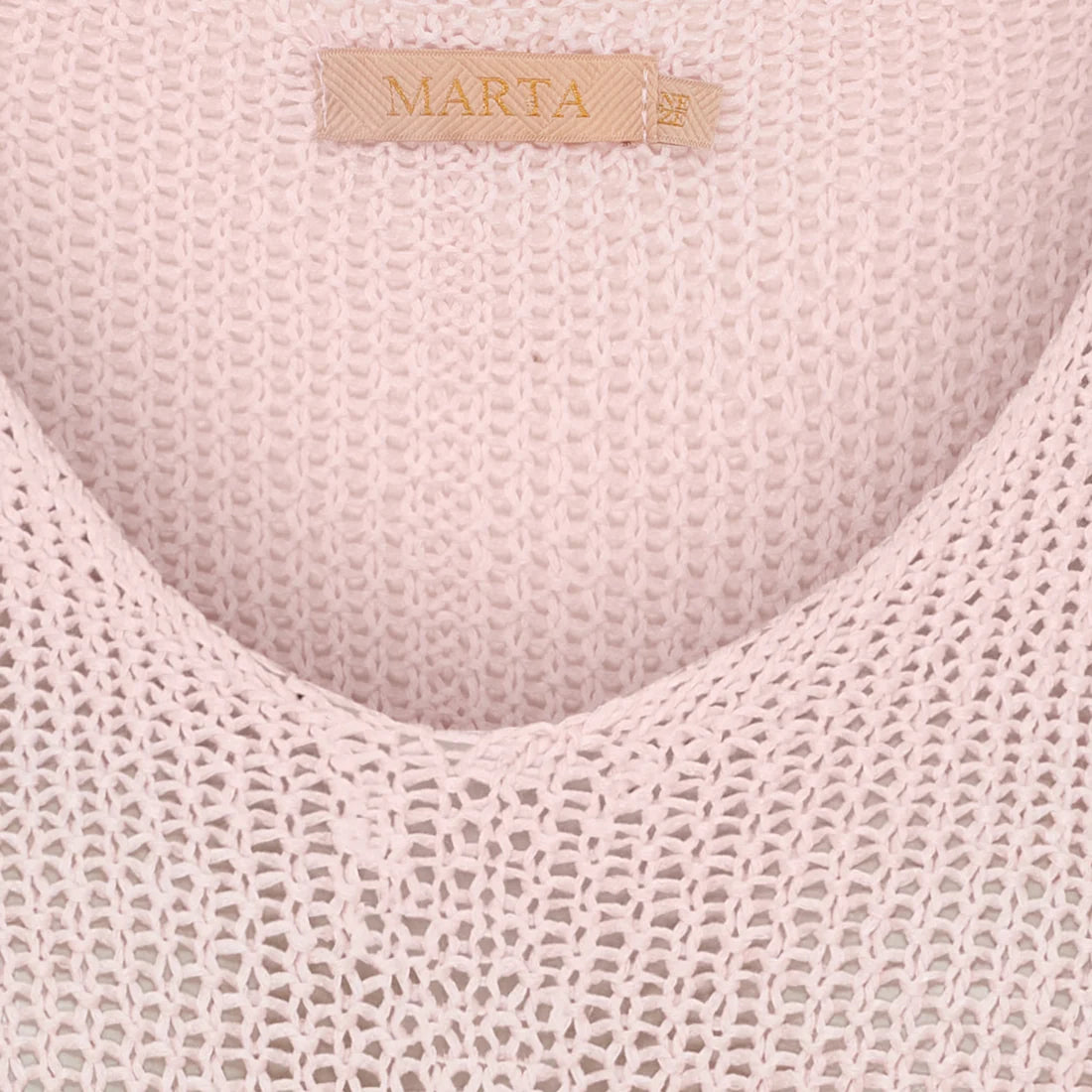 Close-up of a textured pink fabric with 'Marta' branding.