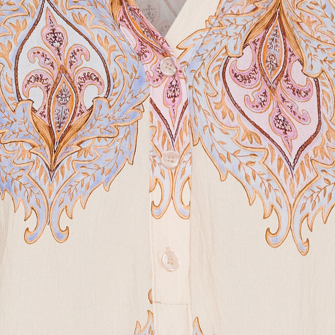 Close-up of a dress with intricate paisley pattern on a beige background