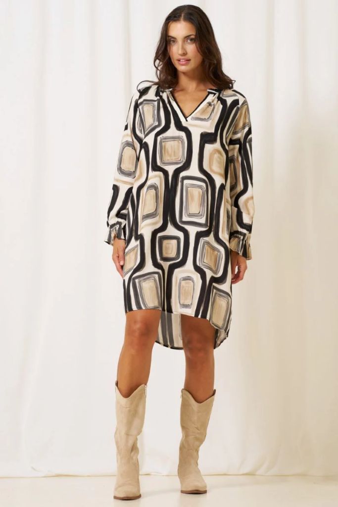 Woman wearing a Marta Du Chateau Estella dress patterned dress with beige boots on a white background