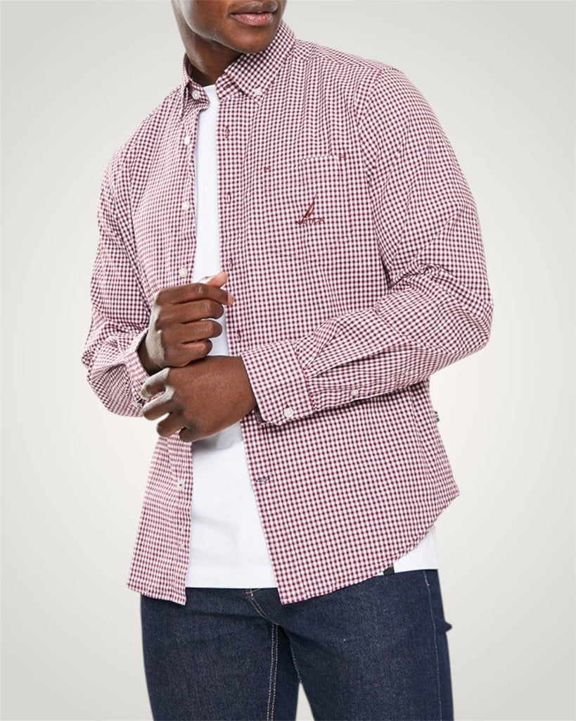 Person wearing a red and white checkered shirt over a white shirt with rolled-up sleeves.