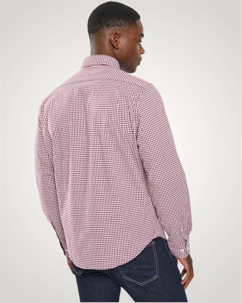 Man wearing a red and white checkered shirt on a gray background
