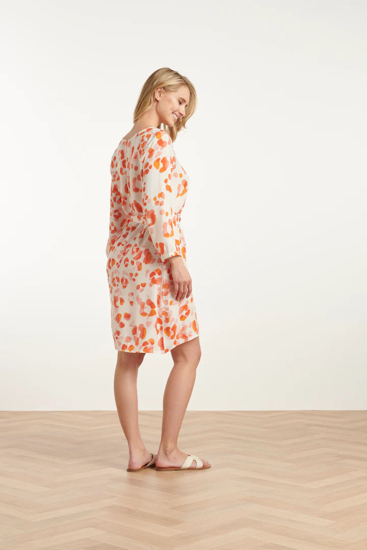 Woman wearing a Smashed Lemon leopard print dress standing on a wooden floor with a white background