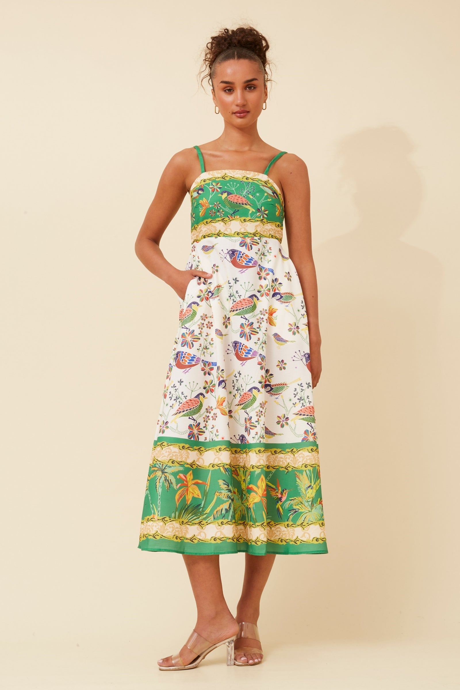Woman wearing, Stella Morgan D733248 Dress , a colorful dress with bird patterns on a beige background