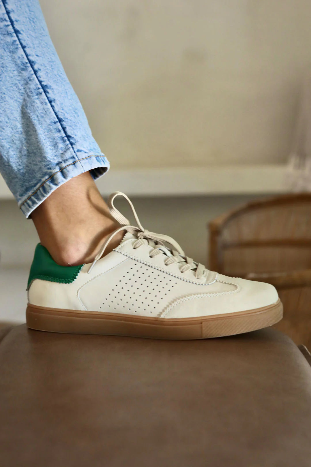 Side view on model cream leather lace up sneaker shoe with green heel detail