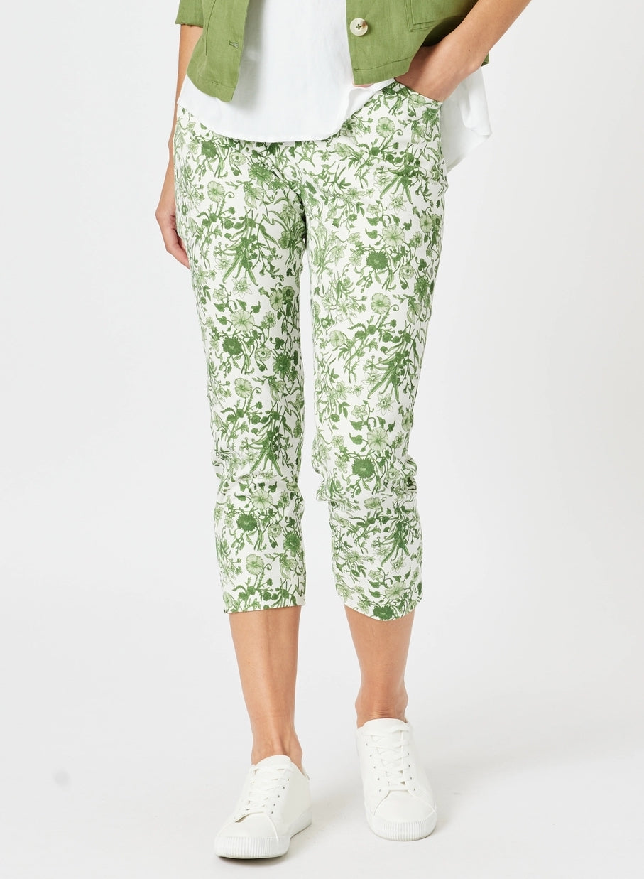 Person wearing green floral capri pants on a white background