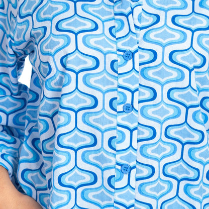 Close-up of a blue and white patterned shirt with geometric shapes.