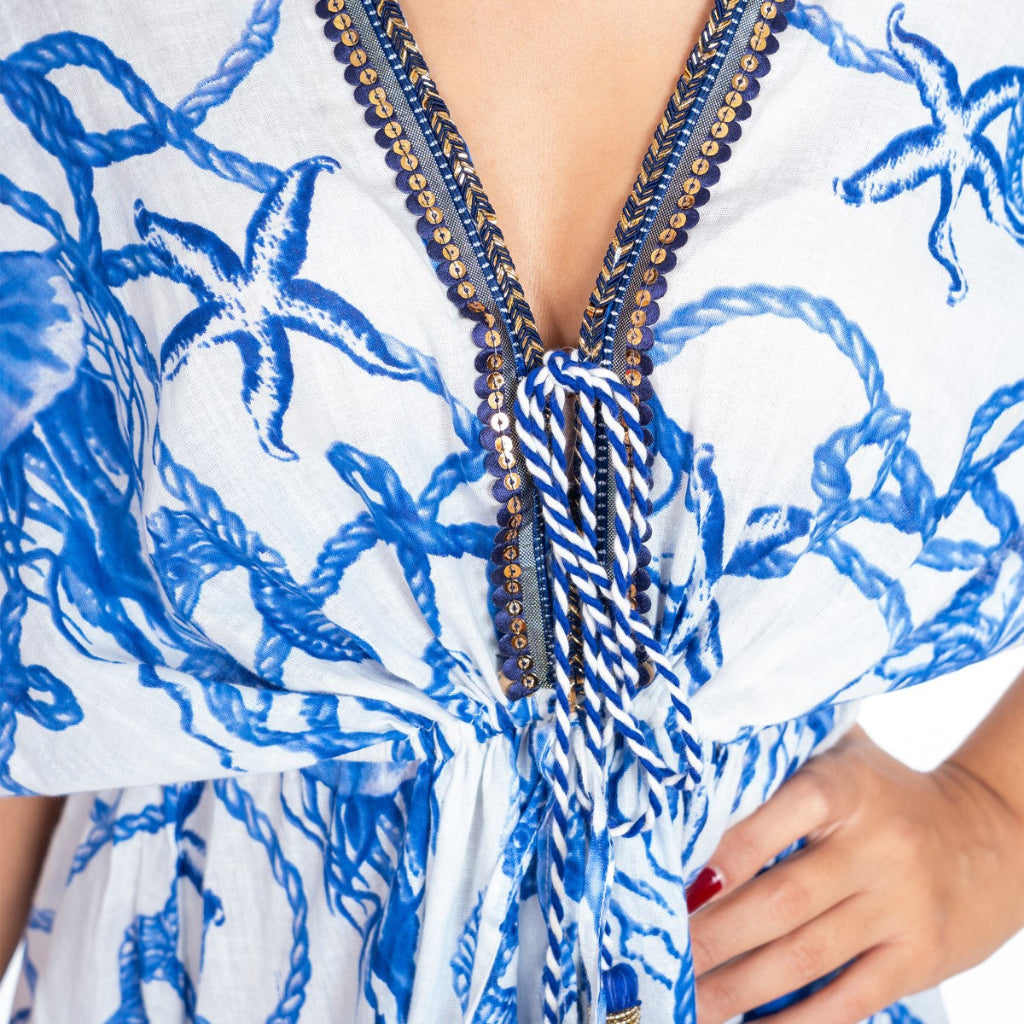 Blue and white patterned dress with decorative elements on a blurred background