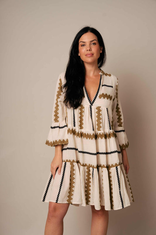 Woman wearing a patterned dress against a plain background