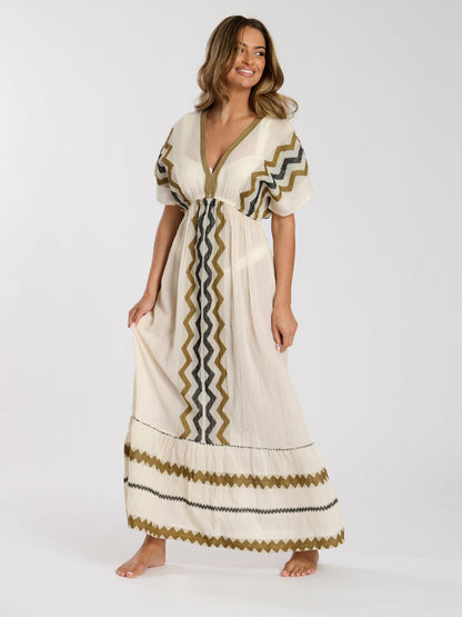 Woman wearing a long, patterned dress on a white background