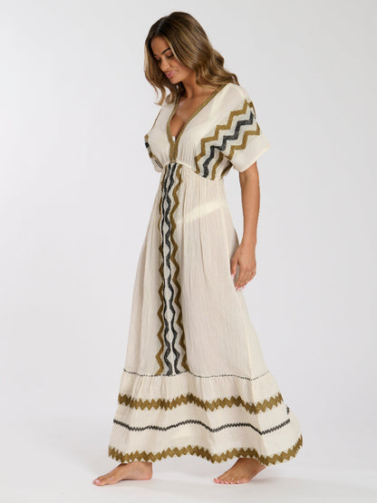 Woman wearing a long, patterned dress on a white background