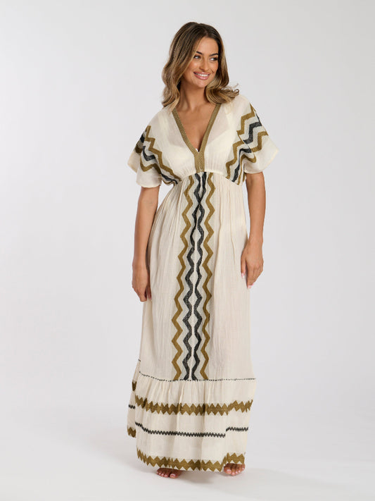 Woman wearing a long, patterned dress on a white background