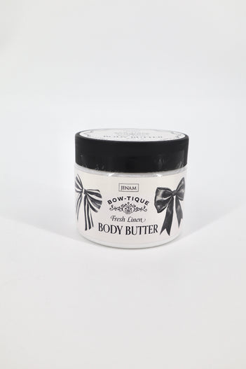 Jar of body butter with black lid and white label on a light gray background