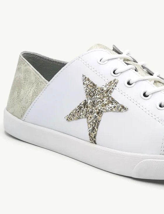 detail shot champagne gold and cream colored leather lace up sneaker