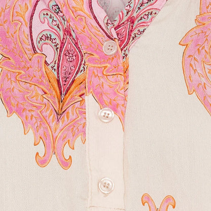 Close-up of a dress with pink and orange paisley pattern on a beige background
