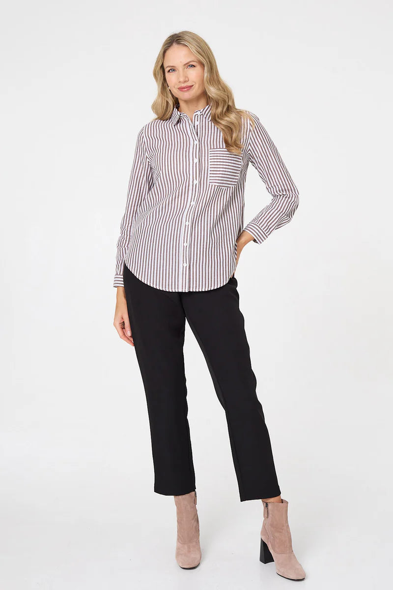 Woman wearing a striped shirt and black pants on a white background