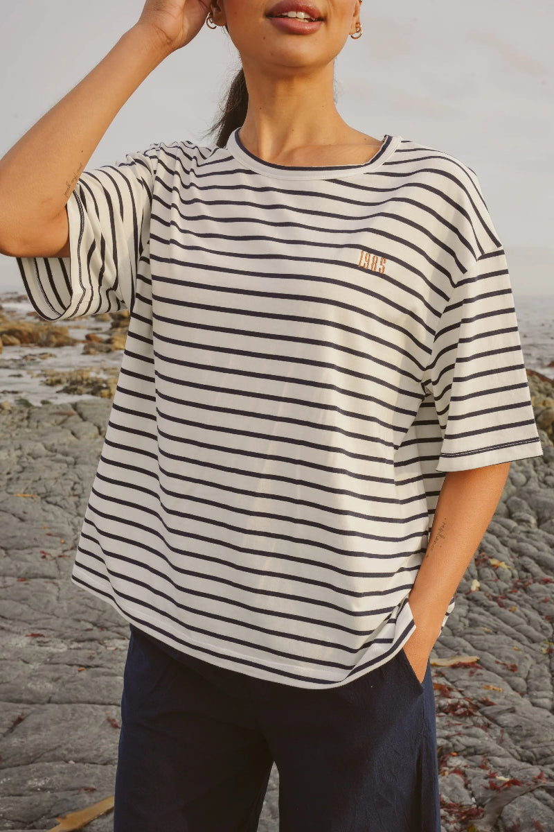 Person wearing a striped shirt on a rocky beach